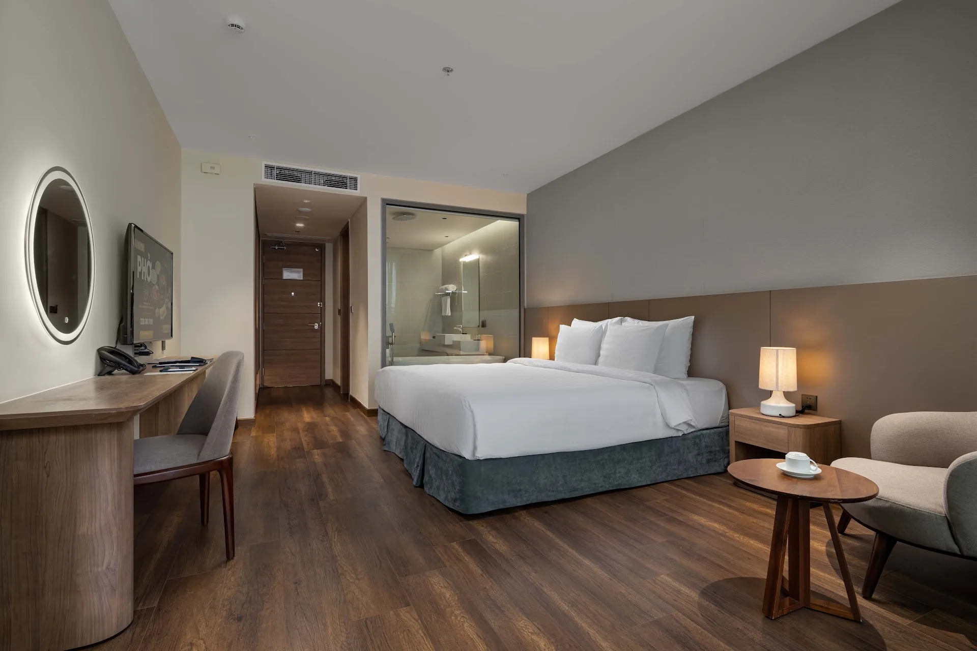 Phòng Deluxe Hướng Biển với bàn làm việc, gương tròn và phòng tắm vách kính