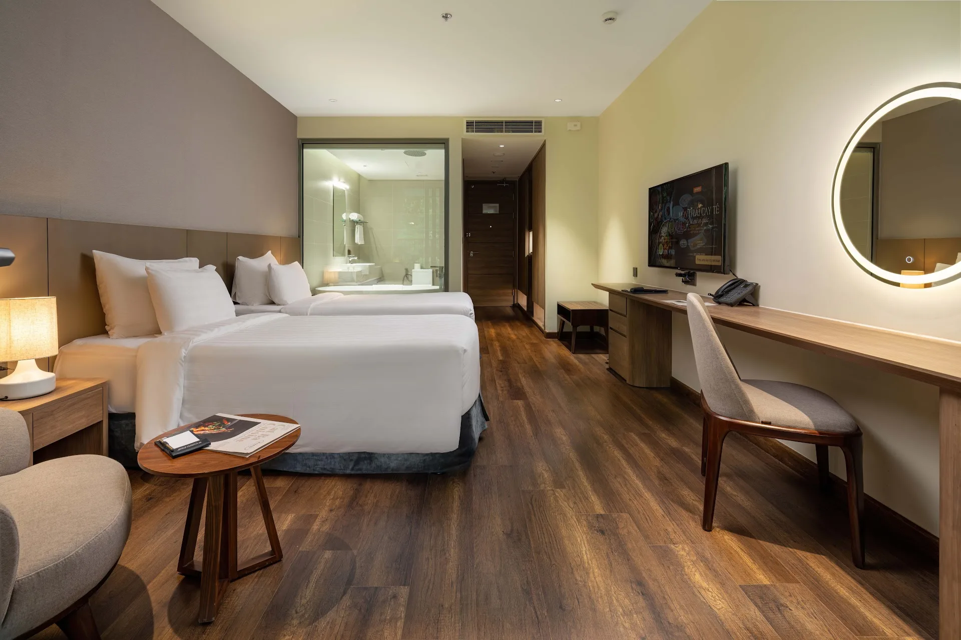 Phòng Deluxe Hướng Núi với gương tròn, góc ngồi thư giãn và phòng tắm vách kính
