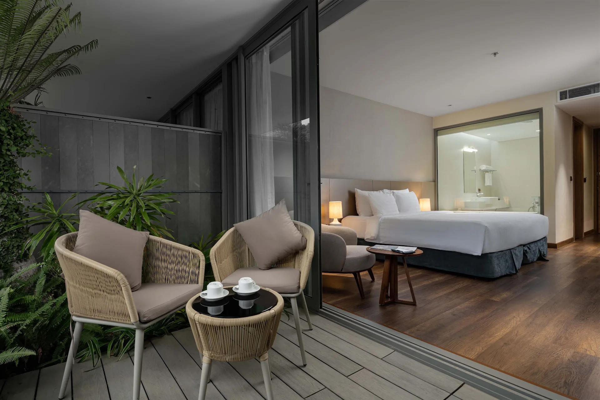 Ban công ghế mây của phòng Premier Hướng Núi giữa cây xanh